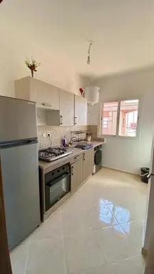 a kitchen with a refrigerator and a stove top oven at Mhamid Appartement 3 chambres in Marrakech