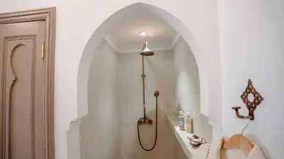 a white bathroom with a sink and a hallway at Riad Lalla Sofia à 200m des tombeaux Saadiens in Marrakech