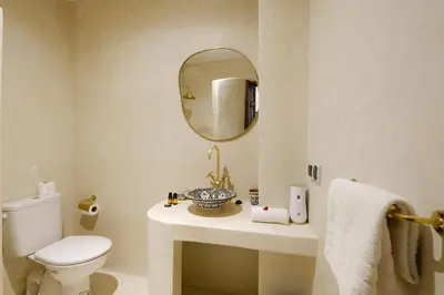 a bathroom with a toilet and a sink and a mirror at Riad Armonia in Marrakech