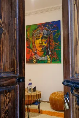 a painting of a woman on a wall at Riad Armonia in Marrakech