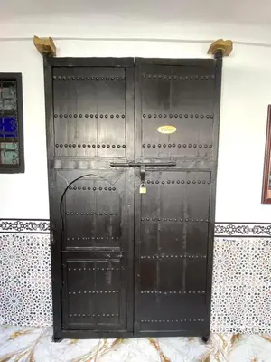 a large black door in a wall at Riad El yacout in Marrakech