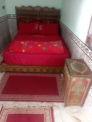 a bed and a box in a room at Riad El yacout in Marrakech