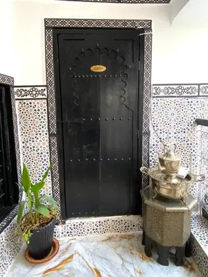 a black door with a plant in front of it at Riad El yacout in Marrakech