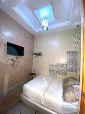 a bedroom with a bed with a tv and a ceiling at Dar Hiba in Marrakech