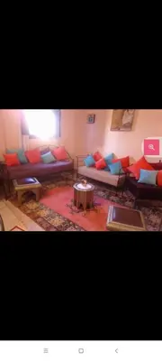 a living room with couches and a table and a laptop at Dar Hiba in Marrakech
