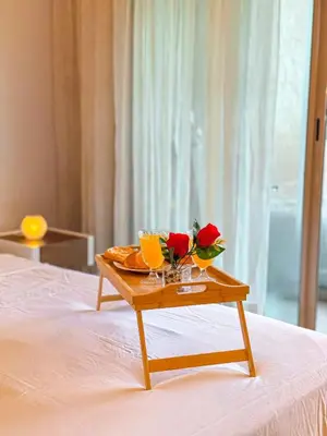 a table with drinks and flowers on top of a bed at VIVASTAY Marrakech - Prestigia Topaze- Terrace overlooking garden & pool in Marrakech