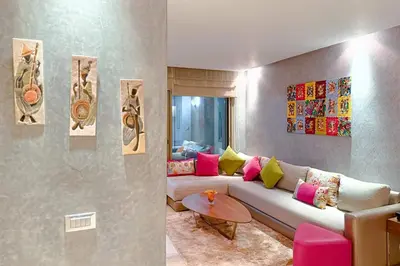 a living room with a couch with colorful pillows at VIVASTAY Marrakech - Prestigia Topaze- Terrace overlooking garden & pool in Marrakech