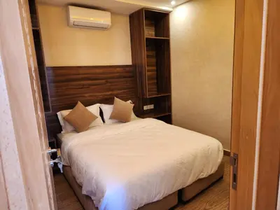 a bedroom with a bed with white sheets and pillows at Appartement Aéroport Holiday in Marrakech