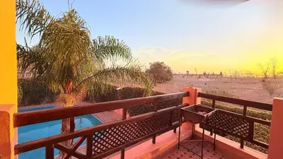 a balcony with a view of the desert and a pool at HiverLux in Marrakech