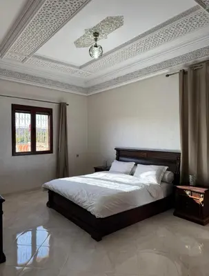 a bedroom with a bed and a ceiling at Maison luxueuse méga spacieuse in Marrakech