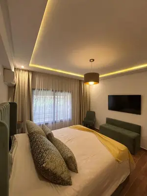 a bedroom with a bed with pillows and a television at Spacieux duplex 3 chambres - Piscine et parking in Marrakech