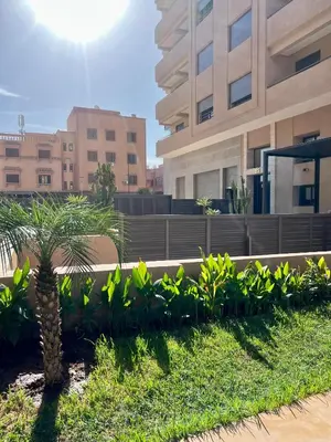 a palm tree in front of a building at Spacieux duplex 3 chambres - Piscine et parking in Marrakech