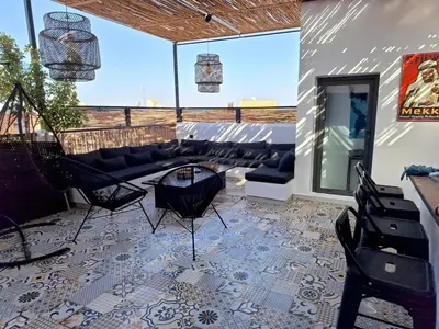 a patio with a couch and a table and chairs at Exceptional duplex apartment in Guéliz with Jacuzzi in Marrakech