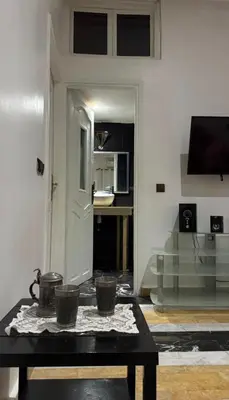 a living room with a table and a kitchen at Appartement au centre de Marrakech in Marrakech