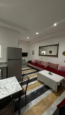 a living room with a red couch and a table at Appartement au centre de Marrakech in Marrakech