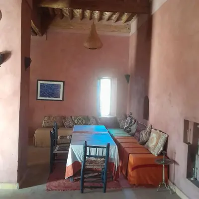 a living room with a table and a couch at Chants des dunes in Marrakech