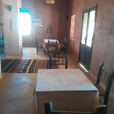 a dining room with a table and chairs and a table and a table and chairs at Chants des dunes in Marrakech