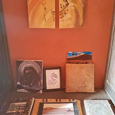 a shelf with pictures and other items on a wall at Chants des dunes in Marrakech