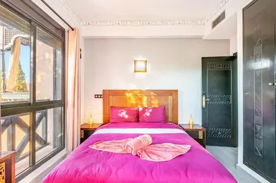 a bedroom with a large pink bed with pink sheets at Nid Andalou balcony and calm in Oulad Akkou