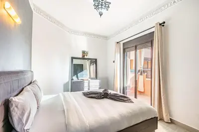 a bedroom with a bed and a mirror and a window at Nid Andalou balcony and calm in Oulad Akkou