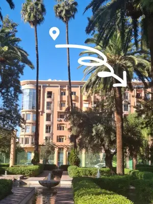 a building with palm trees in front of it at Central Atlas View in Marrakech