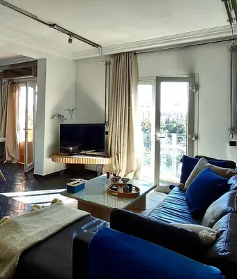 a living room with a blue couch and a tv at Central Atlas View in Marrakech
