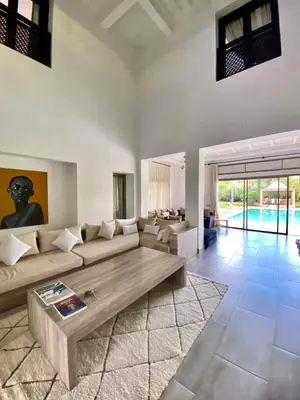 a living room with a couch and a table at Luxueuse villa avec piscine et magnifique jardin in Gzoula