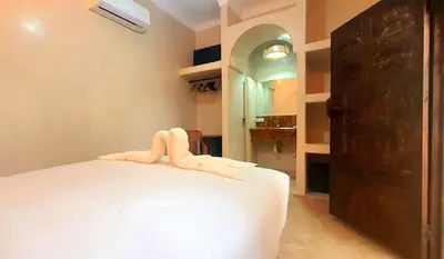 a bedroom with a white bed and a hallway at Riad Keke 4 suites - Pool&Rooftop - Bahia in Marrakech