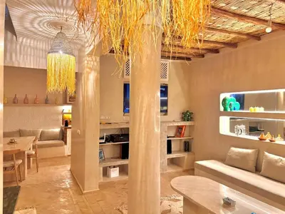a living room with a pillar and a dining room at Riad Keke 4 suites - Pool&Rooftop - Bahia in Marrakech