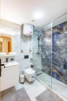 a bathroom with a glass shower and a toilet at Studio chic Guéliz à deux pas de Carré Eden Avec Parking in Marrakech