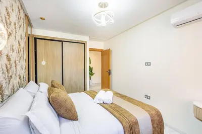 a bedroom with a large white bed with two pillows at Studio chic Guéliz à deux pas de Carré Eden Avec Parking in Marrakech