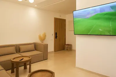 a living room with a couch and a tv on a wall at Sophisticated & Cozy Home in Vibrant Marrakech in Marrakech