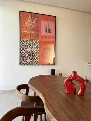 a table with two chairs and a painting on the wall at Villa Marraktus Marrakech in Marrakech