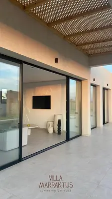 a lobby with sliding glass doors and a flat screen tv at Villa Marraktus Marrakech in Marrakech