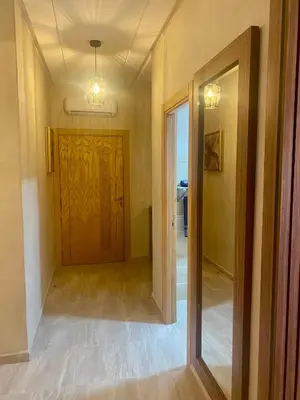 a hallway with a wooden door and a mirror at Appartement de luxe avec piscine in Marrakech