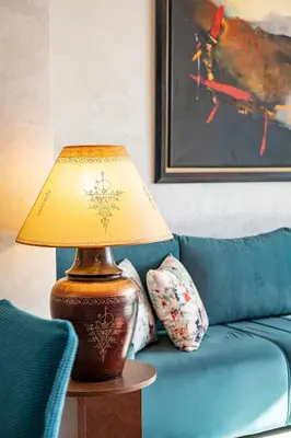 a lamp on a table next to a blue couch at Charming apartment in the center of Victor Hugo Gueliz in Marrakech
