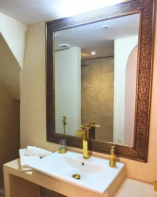 a bathroom with a sink and a large mirror at Little date in Marrakech