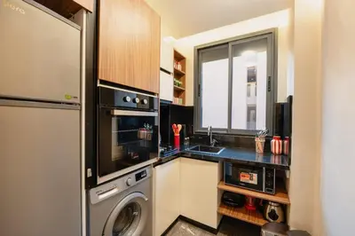 a kitchen with a washing machine and a window at Cocooning escape Relaxation, design and serenity in Marrakech