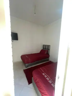 two beds in a room with red sheets at Abwab guiliz in Marrakech