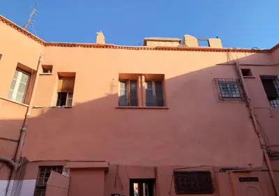 an orange building with windows and a blue sky at Appart Jamaa lafna square in Marrakech