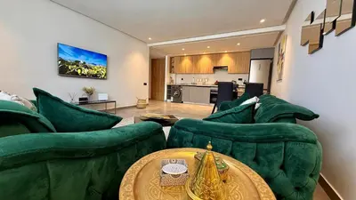 a living room with green couches and a table at Mosaic 54 - Terrasse & Piscine chauffée - M Avenue in Marrakech