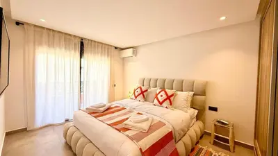 a bedroom with a large bed in front of a window at Mosaic 54 - Terrasse & Piscine chauffée - M Avenue in Marrakech