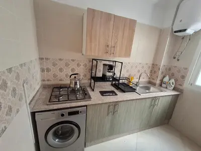 a small kitchen with a washing machine and a sink at Appartement a louer 2 chambres in Marrakech