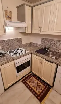 a kitchen with white cabinets and a stove and a sink at Nilia in Marrakech