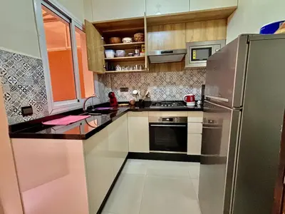 a kitchen with a stainless steel refrigerator and cabinets at Charmant, terrasse intime, près du centre in Marrakech