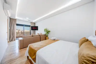 a white bedroom with a large bed and a couch at Guéliz 7 Appartements in One Building in Marrakech