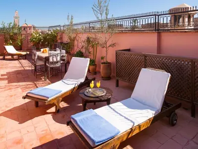two lounge chairs and a table on a patio at Riad Darhani - Private use option - in Marrakech
