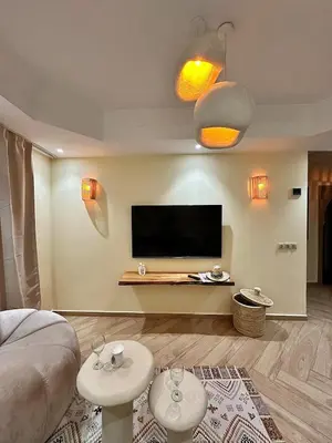 a living room with a bed and a flat screen tv at Downtown Feng Shui-style apartment with mountain view in Marrakech