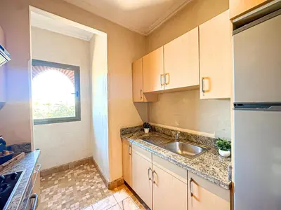 a small kitchen with a sink and a refrigerator at Oasis Palmeraie - Piscines & terrasses in Marrakech