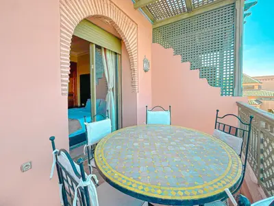 a patio with a table and chairs on a balcony at Oasis Palmeraie - Piscines & terrasses in Marrakech